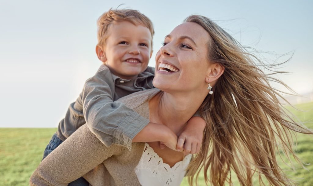 Una mamma giovane con il suo bambino, che la abbraccia da dietro